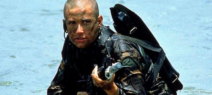 Jordan (Demi Moore) de uniforme e segurando uma metralhadora em Até o Limite da Honra