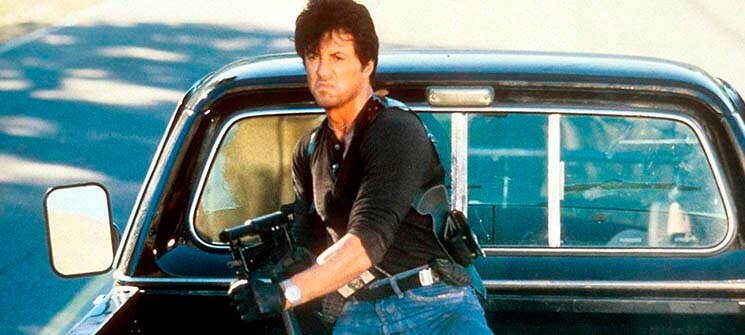 Cobra (Sylvester Stallone) segurando uma metralhadora