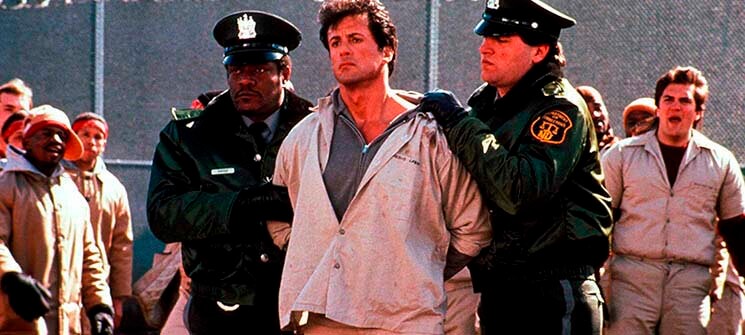 Frank (Sylvester Stallone) sendo guiado por guardas para cadeia