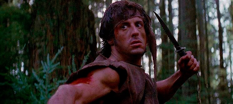 Rambo (Sylvester Stallone) segurando uma faca