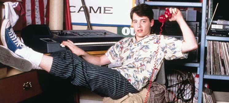 Ferris Bueller sentado no filme Curtindo a Vida Adoidado (1986)