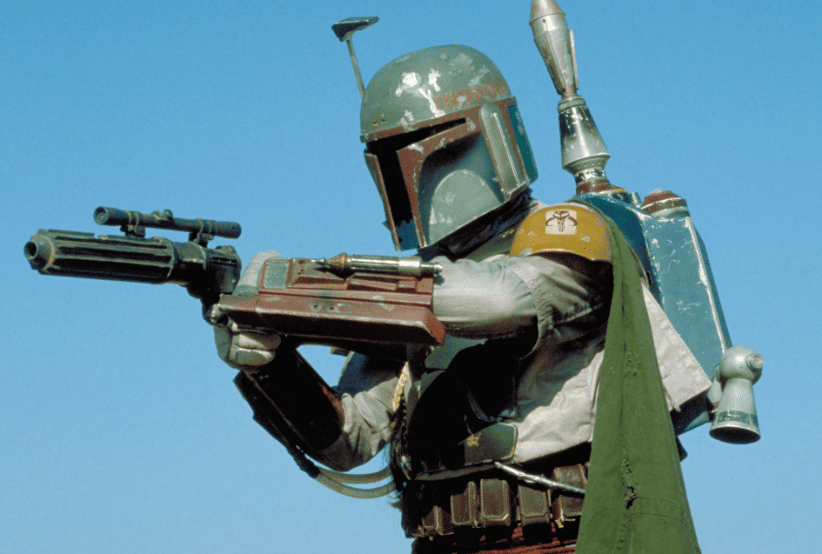 Boba Fett interpretado por Jeremy Bulloch segurando uma arma laser em O Império Contra-Ataca. Um dos personagens mais famosos dos anos 80.