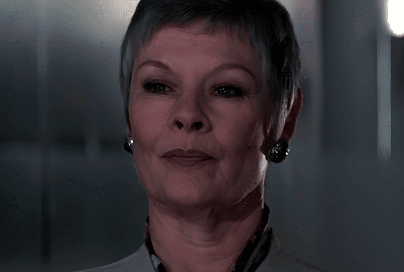 M (Judi Dench) sentanda em uma cadeira em 007 Contra GoldenEye.30 personagens femininas que marcaram a história do cinema