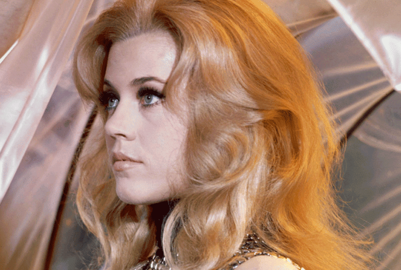 Barbarella (Jane Fonda) deitada e segurando uma arma laser. 30 personagens femininas que marcaram a história do cinema