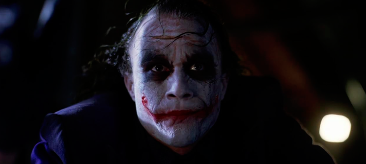 Heath Ledger como Coringa, pendurado de cabeça para baixo no filme O Cavaleiro das Trevas