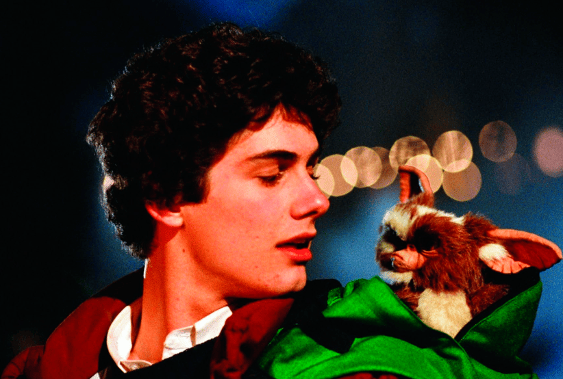 Billy (Zach Galligan) ao lado de Gismo no filme Gremlins. Em uma lista dos melhores filmes de natal.