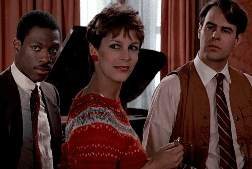 Dan Aykroyd, Jamie Lee Curtis e Eddie Murphy em Trocando as Bolas. Em uma lista que reúne os melhores filmes de Eddie Murphy